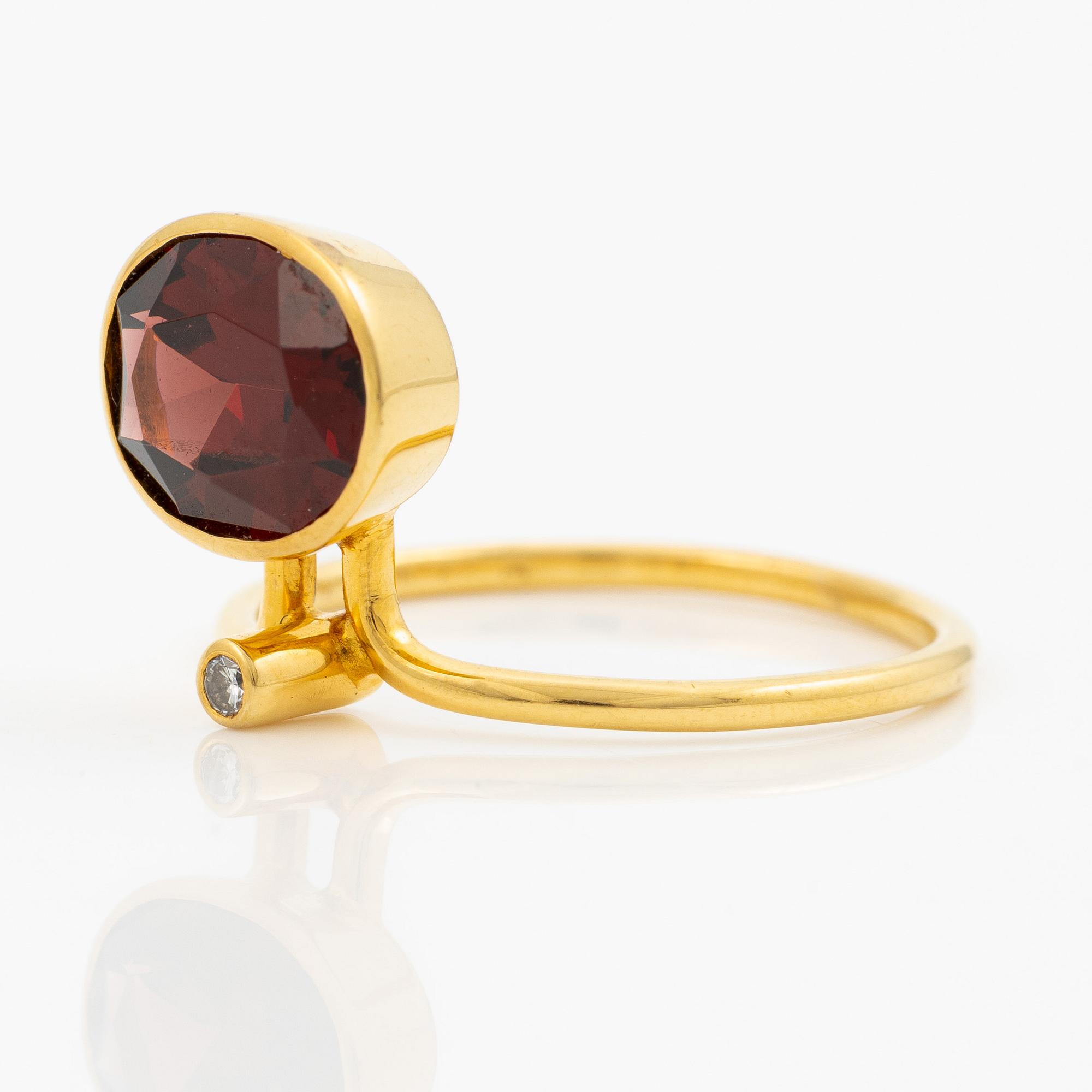 Ring in 18K gold with an oval faceted garnet and a brilliant-cut diamond.