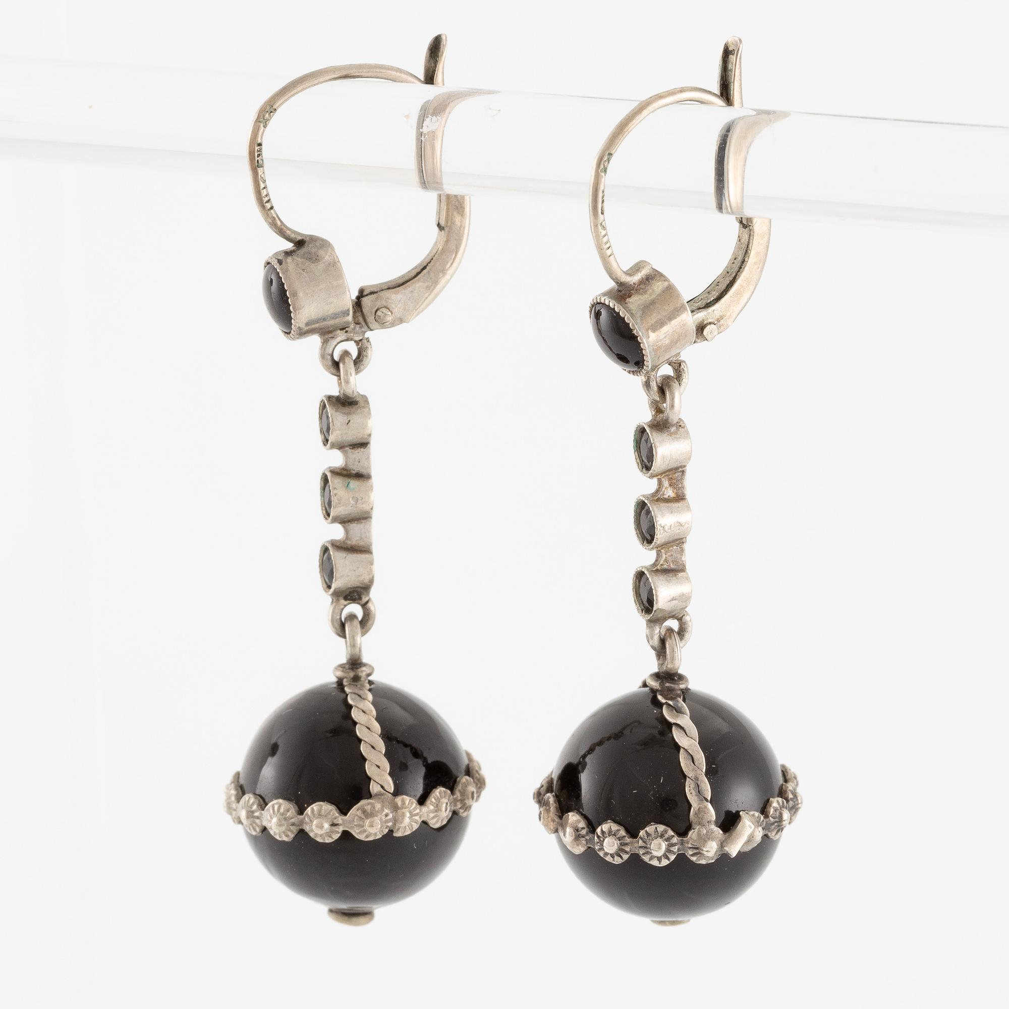 Örhängen silver med svarta stenar.