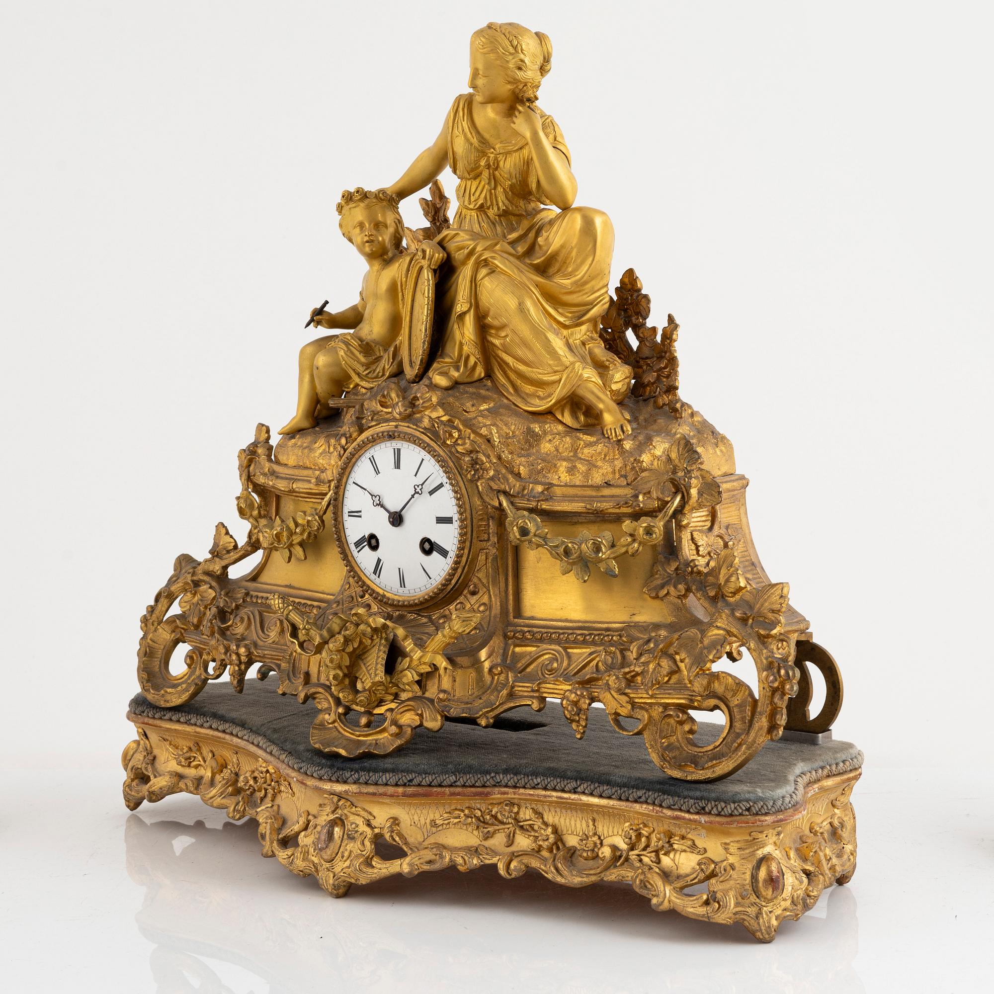 A table clock and a pair of candelabras, Louis XVI-style, France, beginning of the 20th century.