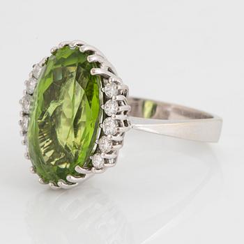 An 18K white gold ring set with an oval faceted peridot ca 11.00 cts and round brilliant-cut diamonds.