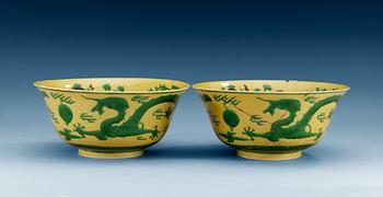1570. A pair of yellow ground 'dragon bowls', Qing dynasty, with Kangxis six character mark.