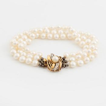 Bracelet, three-stranded with cultured pearls, clasp with a pearl and small diamonds.