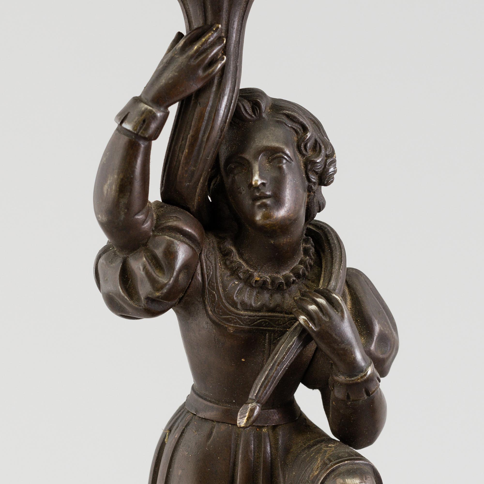 A pair of late 19th century patinated brass candelabra.