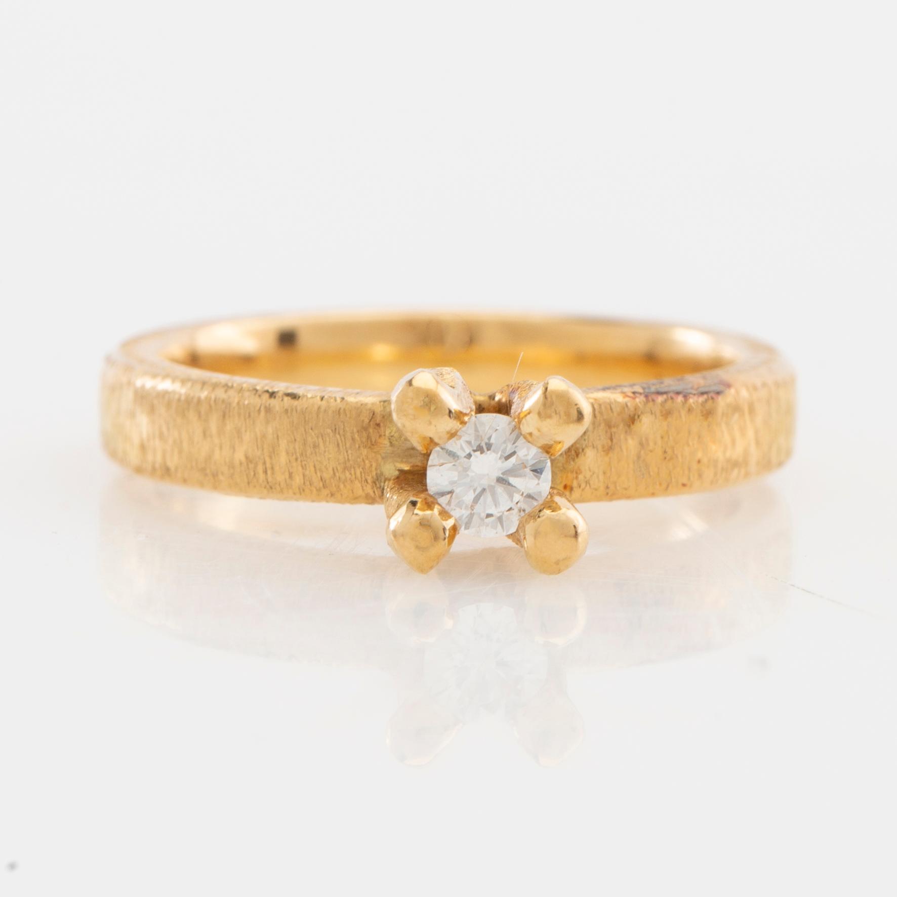 Solitaire ring in 18K gold with a round brilliant-cut diamond.