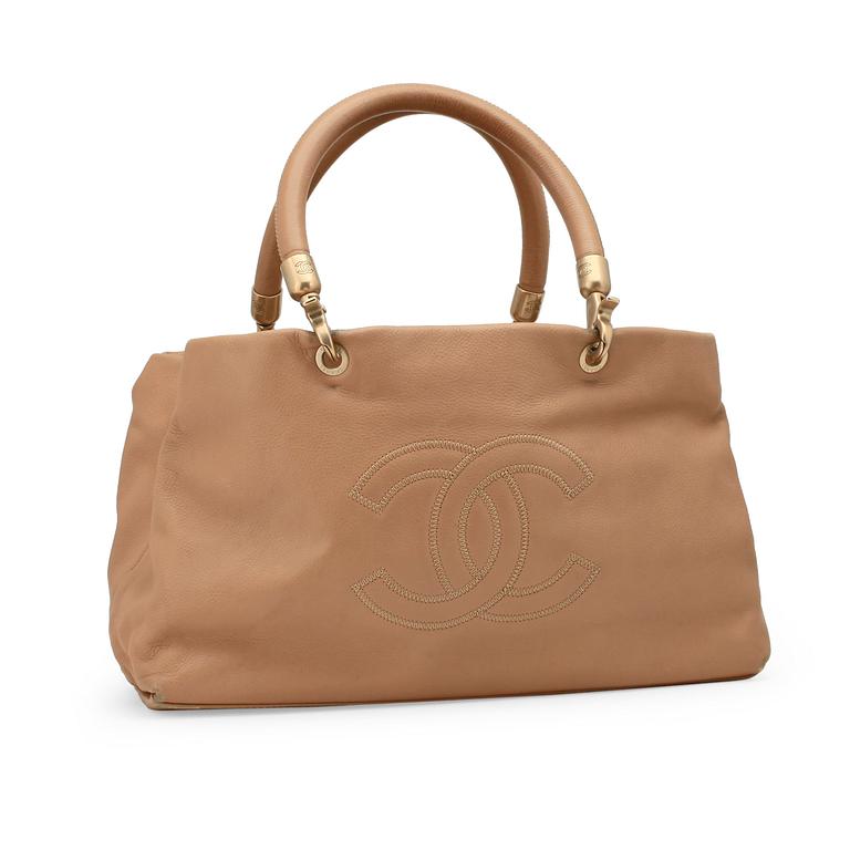 CHANEL, a beige leather handbag.