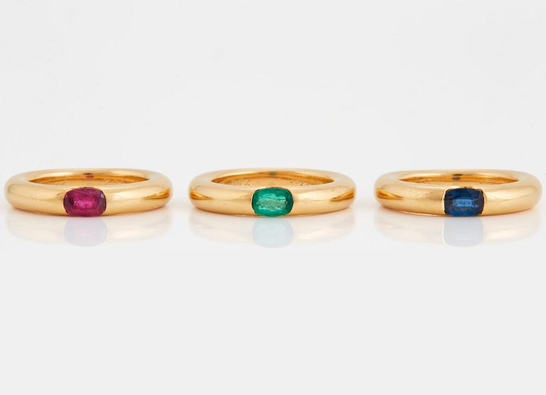Cartier tre ringar "Ellipse" 18K guld med fasettslipad safir, smaragd och rubin.