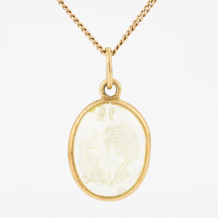 Pendant with yellow-green stone featuring the intaglio of the zodiac sign of Pisces, with a gold chain.