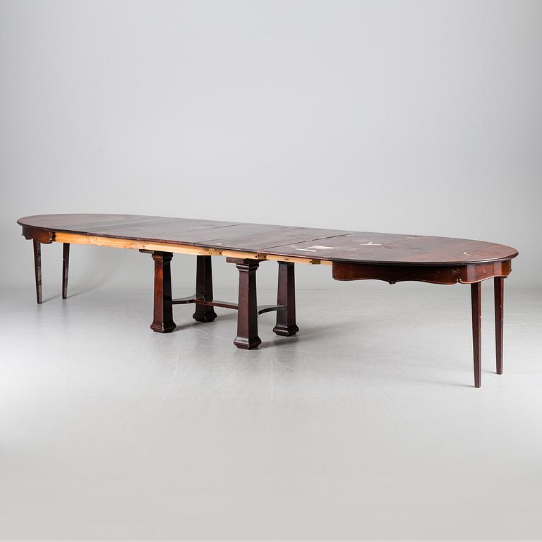 A late 19th century dining table with ten chairs and five extension leaves.