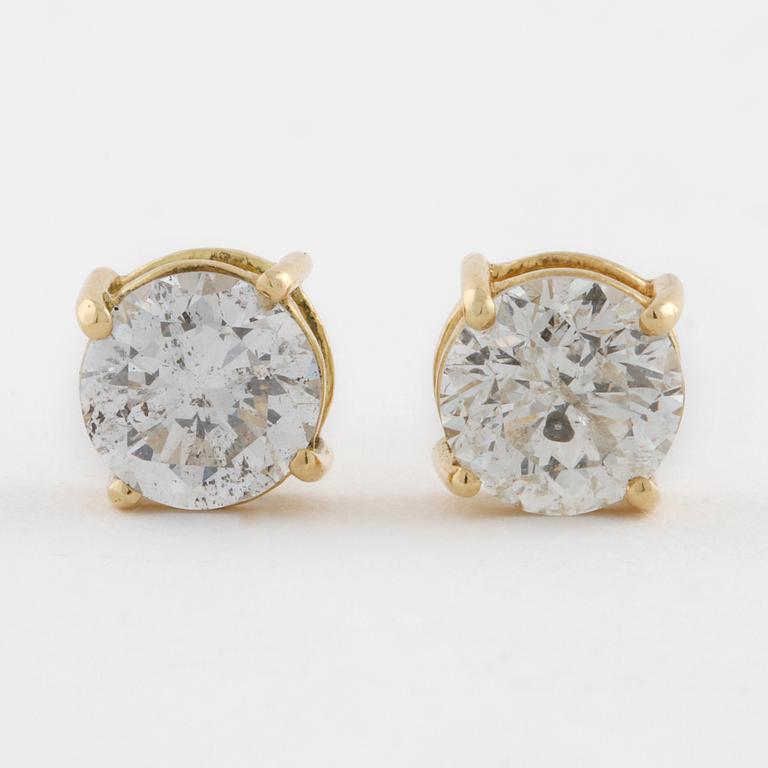 A pair of brilliant cut diamond earrings.