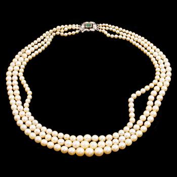 A three strand calibrated pearl necklace, clasp with emerald and diamonds.