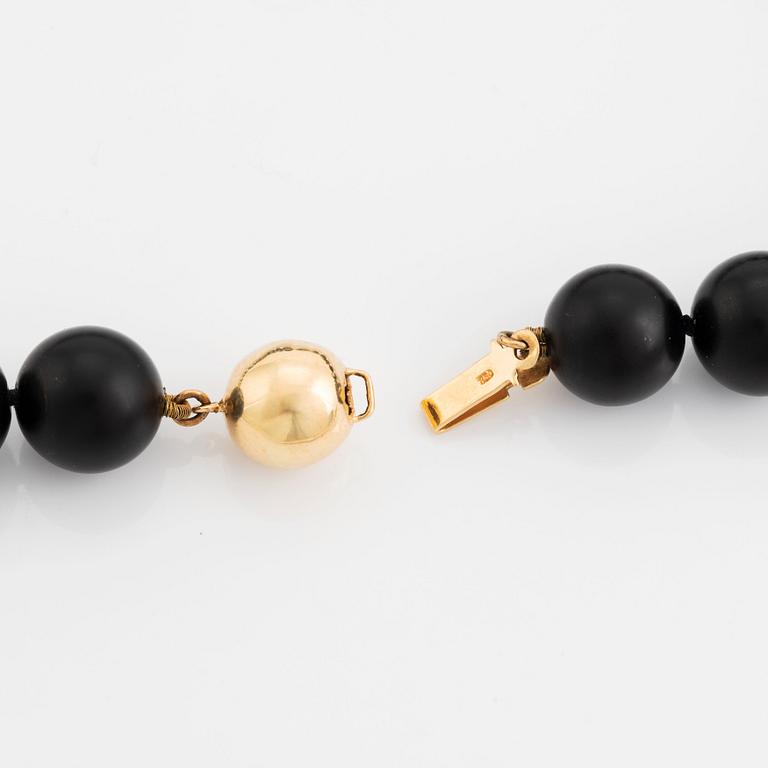 An onyx necklace, a pair of 18K gold earrings with two pairs of pendants in onyx and wood.