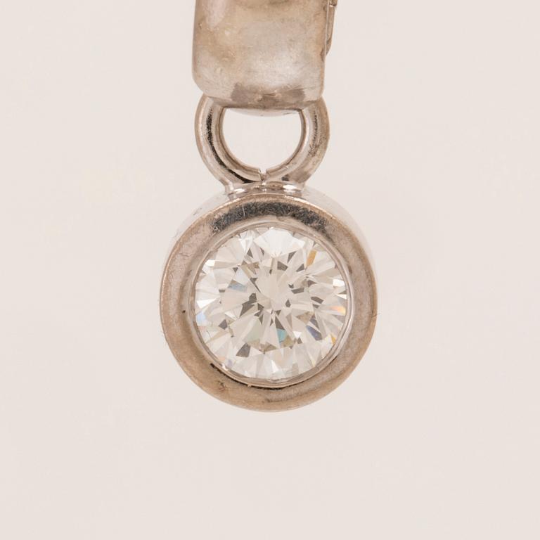 An 18K white gold pendant set with a round brilliant-cut diamond.