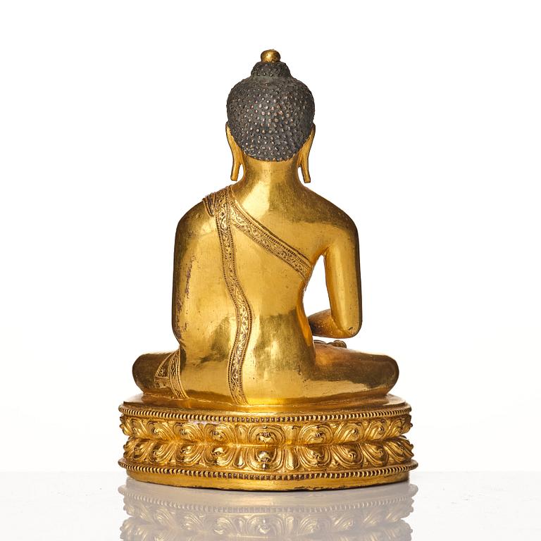 A gilt copper alloy figure of buddha, Tibeto Nepalese, stylistically from the 14th/15th Century,