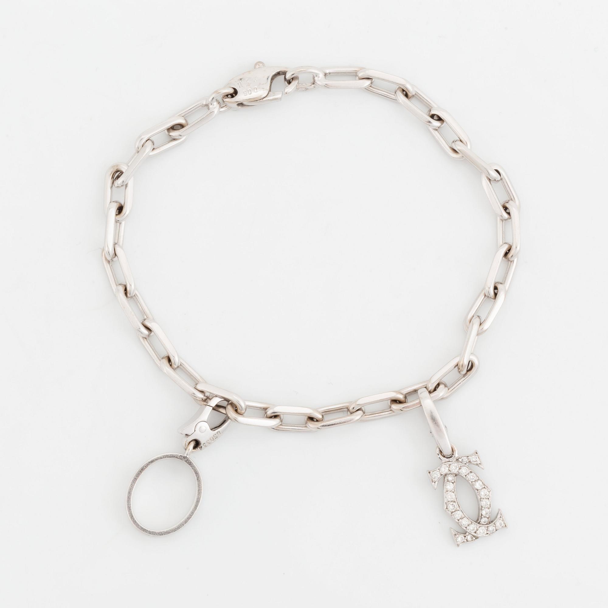 An 18K white gold Cartier Spartacus bracelet with two charms. Bukowskis