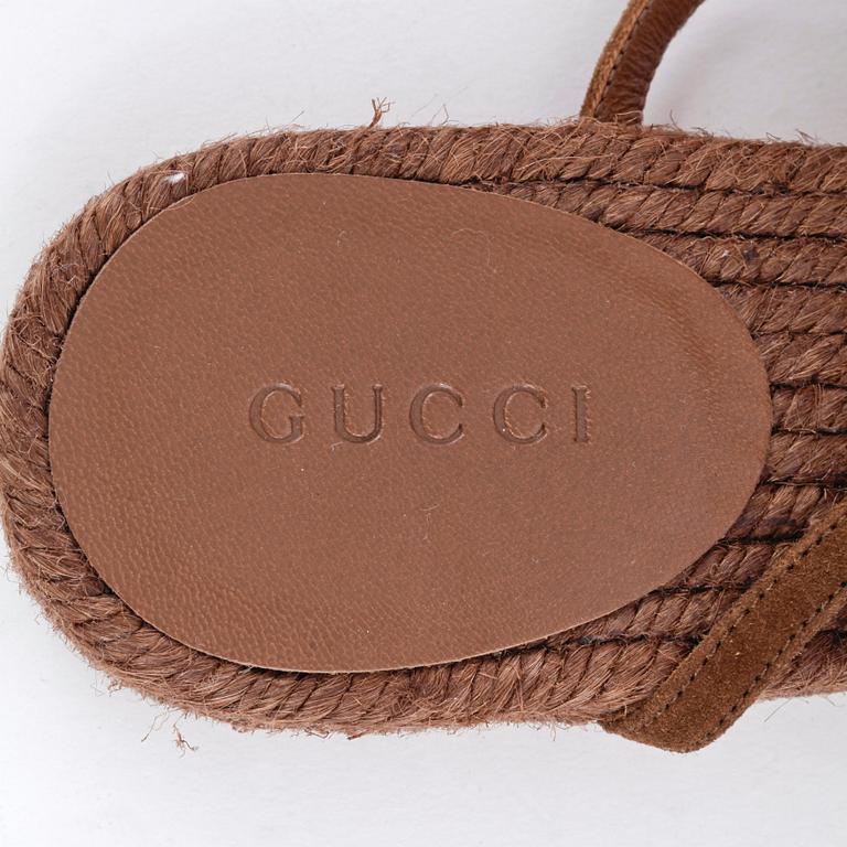 GUCCI, a pair of brown sandals.