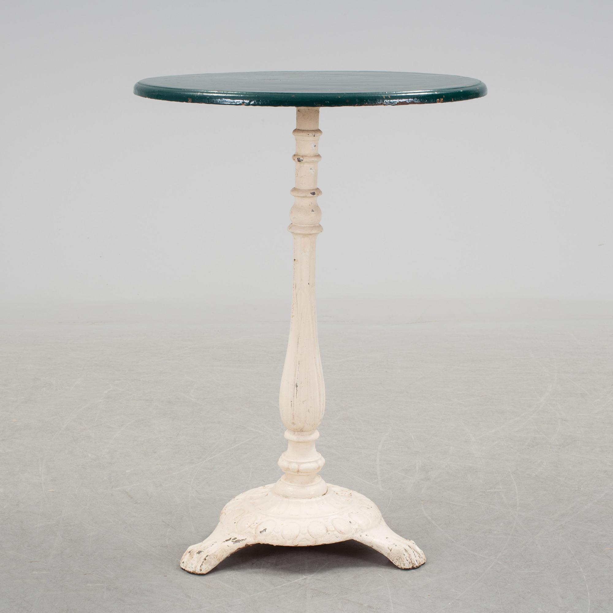 A pair of cast iron chais with wooden seats and a cast iron table, early 20th century.