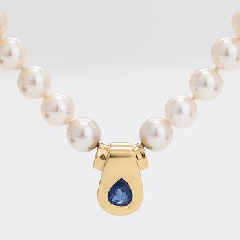 A cultured pearl necklace, pendant in 18K gold with a pearshaped sapphire.