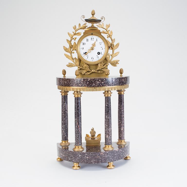 A Swedish Gustavian style porphyry and gilt bronze mantel clock from around year 1900.