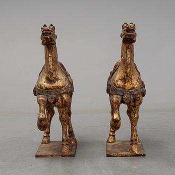 A pair of large Chinese wooden and gilt sculpture of horses, first half of the 20th century.