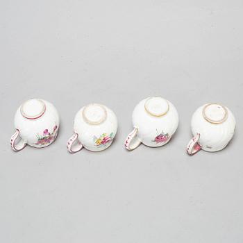 A set of four odd soft paste custard cups with covers, 18th Century.