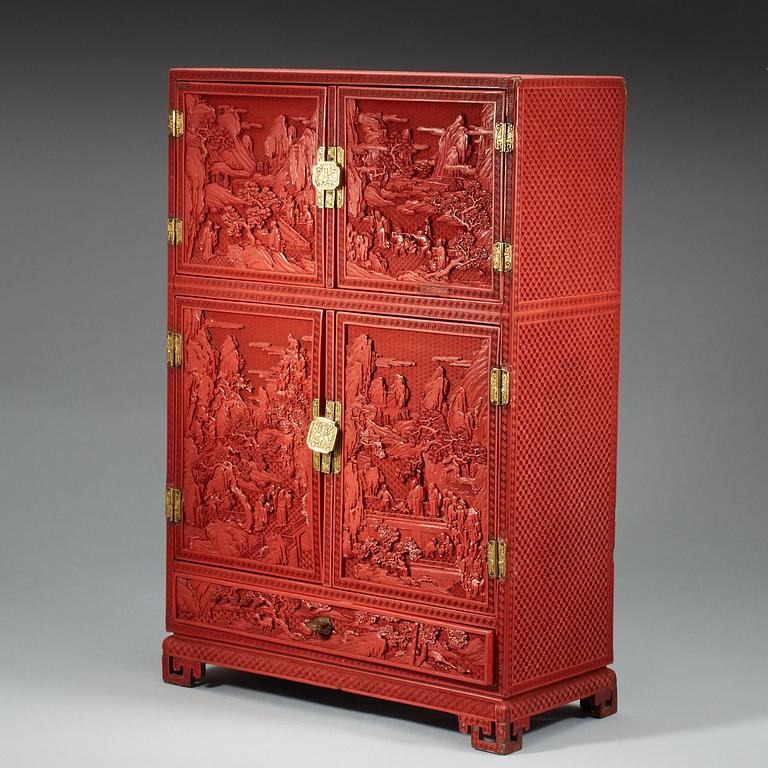 A well carved cinnabar lacquer 'Kang' cabinet, Qing dynasty, 18th century.