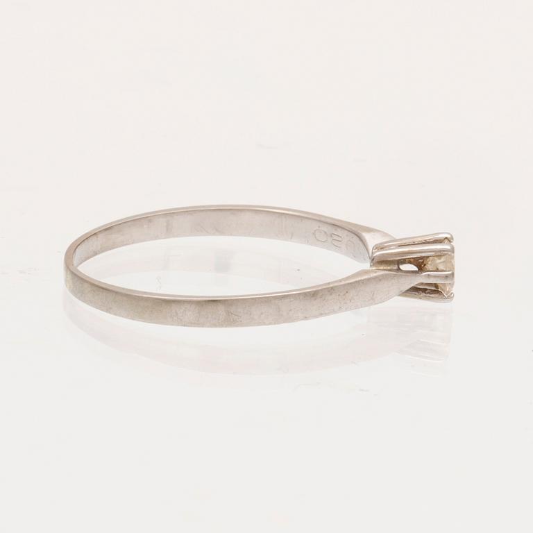 An 18K white gold ring with a round brilliant cut diamond.