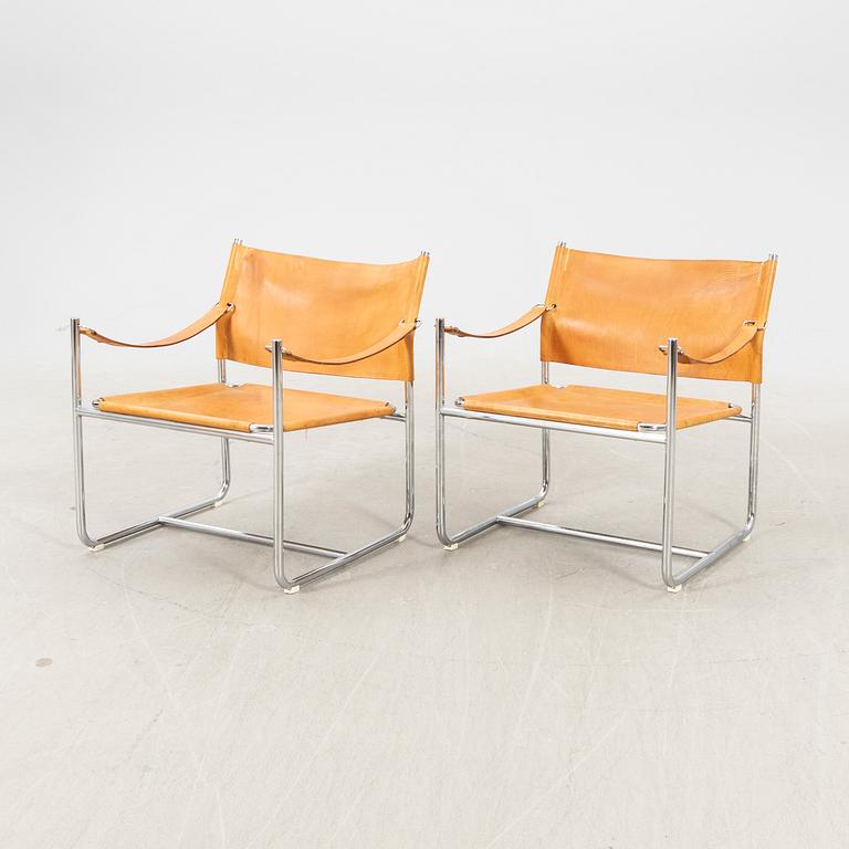 A pair of metal and leather arm chairs by DUX.