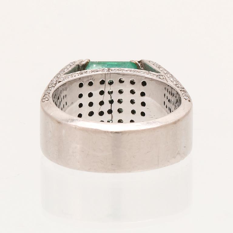 A 9K white gold ring with an emerald and brilliant cut diamonds.