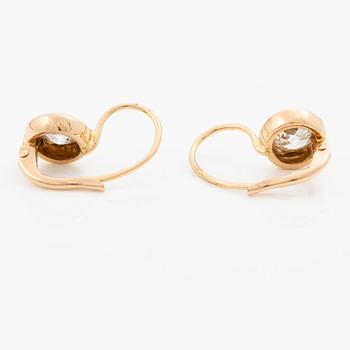 A pair of earrings in 18K gold set with two old-cut diamonds.