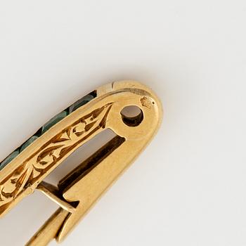 Brosch, längre modell, guld med carréslipade smaragder och gammalslipade diamanter, troligen omkring sekelskiftet 1900.