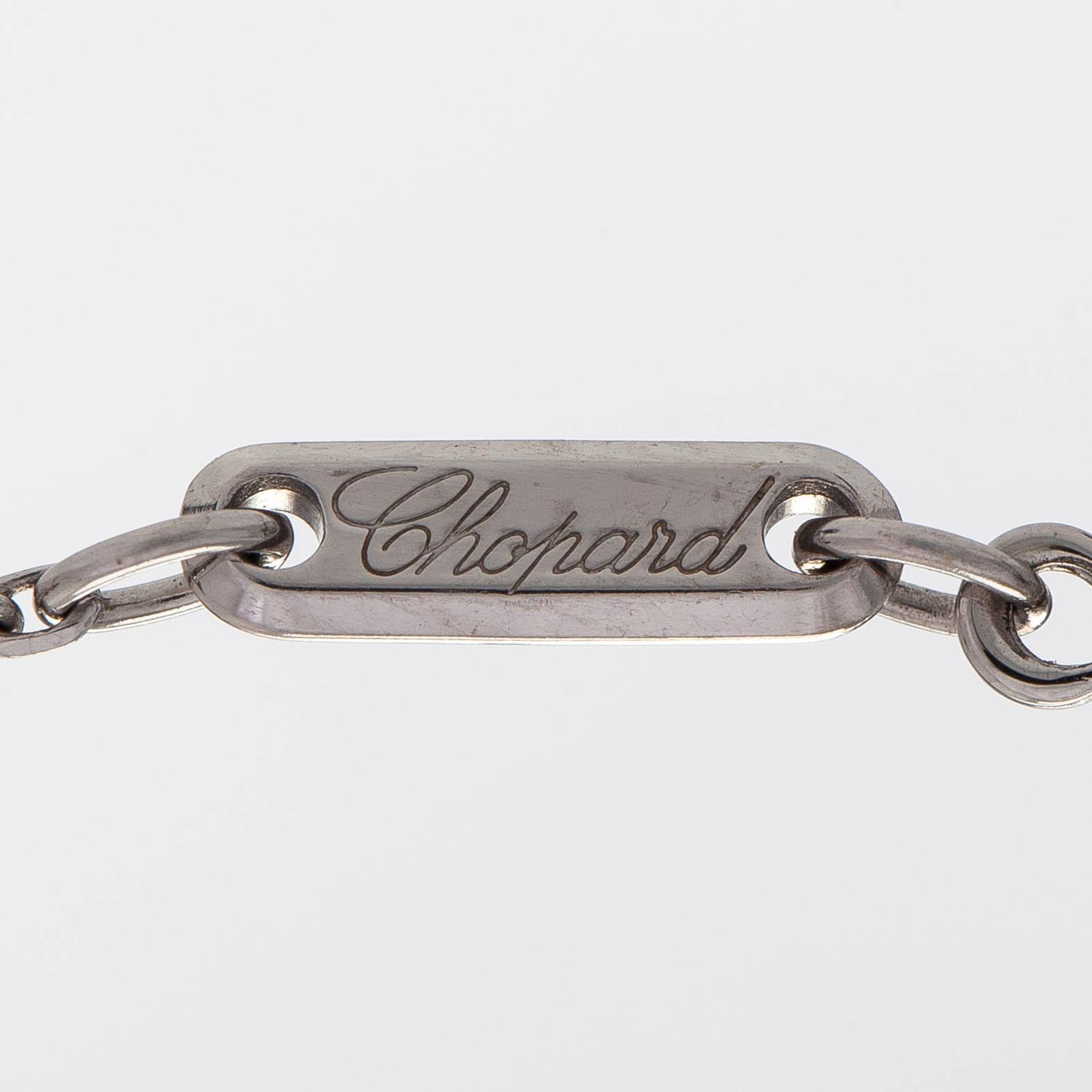 Chopard, an 18K whitegold 'Happy Diamonds" cross necklace set with diamonds.