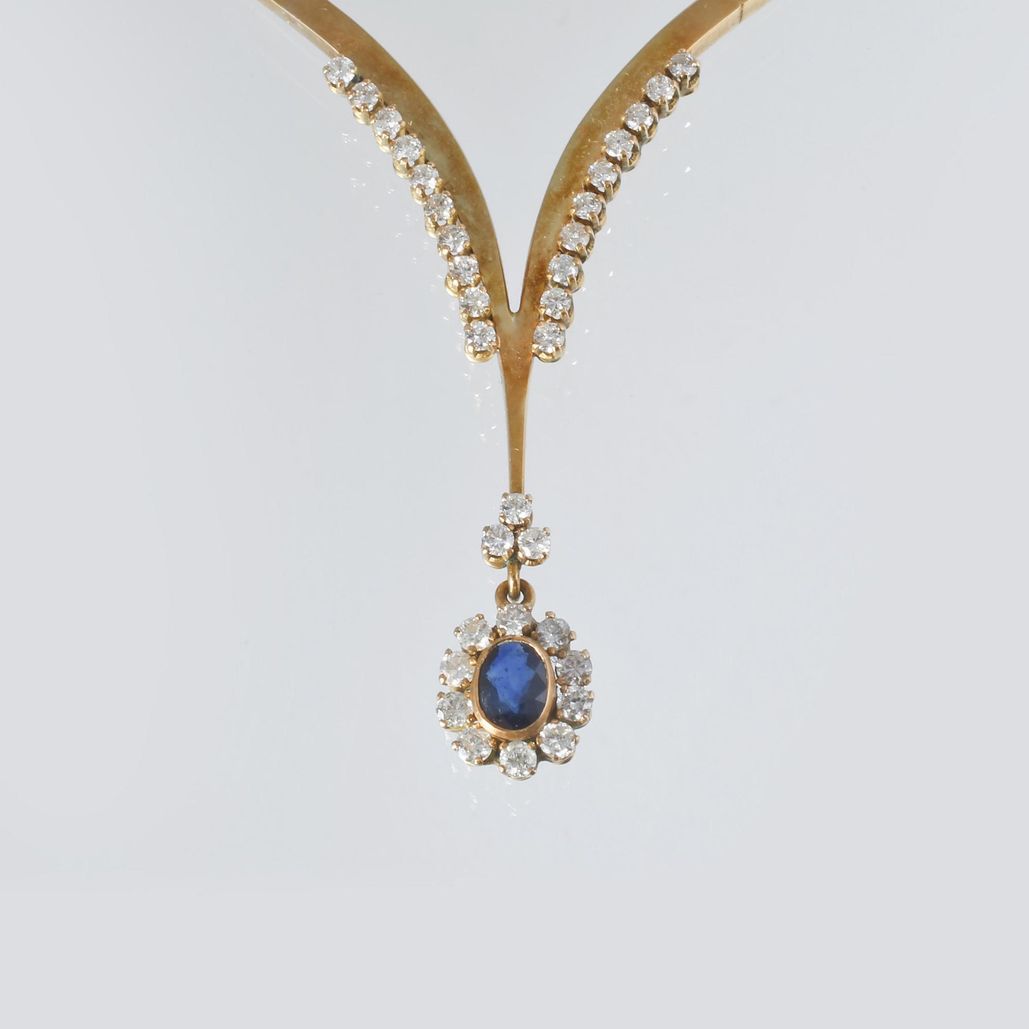 COLLIER, 18K guld med 33 briljantslipade diamanter samt ovalslipad blå safir. Vikt 32,4 gram.