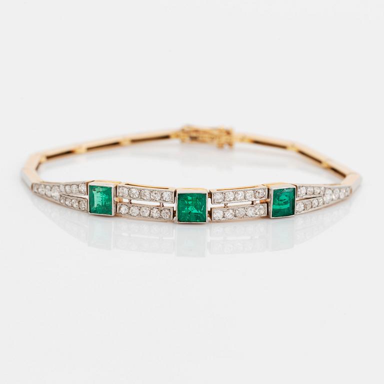 An 18K gold and platinum bracelet set with step-cut emeralds and old- and eight-cut diamonds.