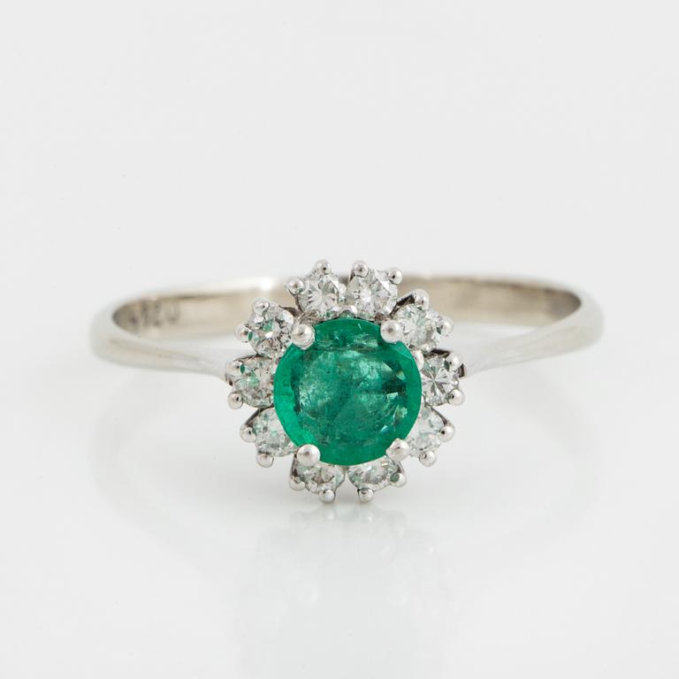 An emerald and brilliant-cut diamond ring.