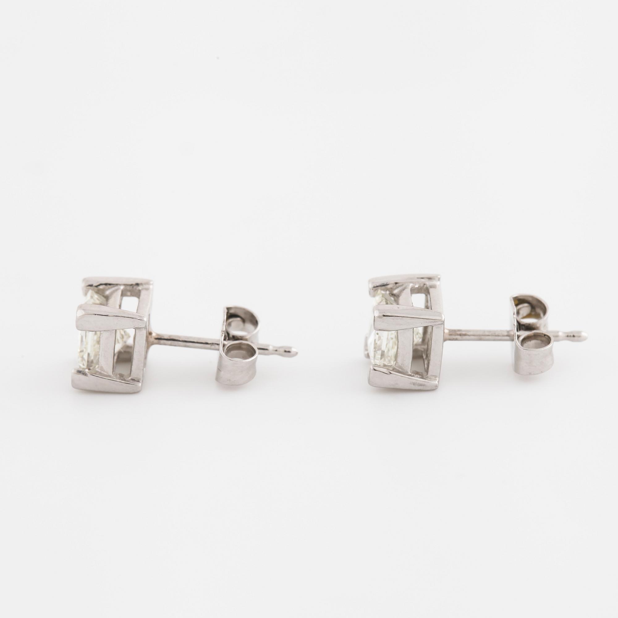 A pair of princess cut diamond earrings.