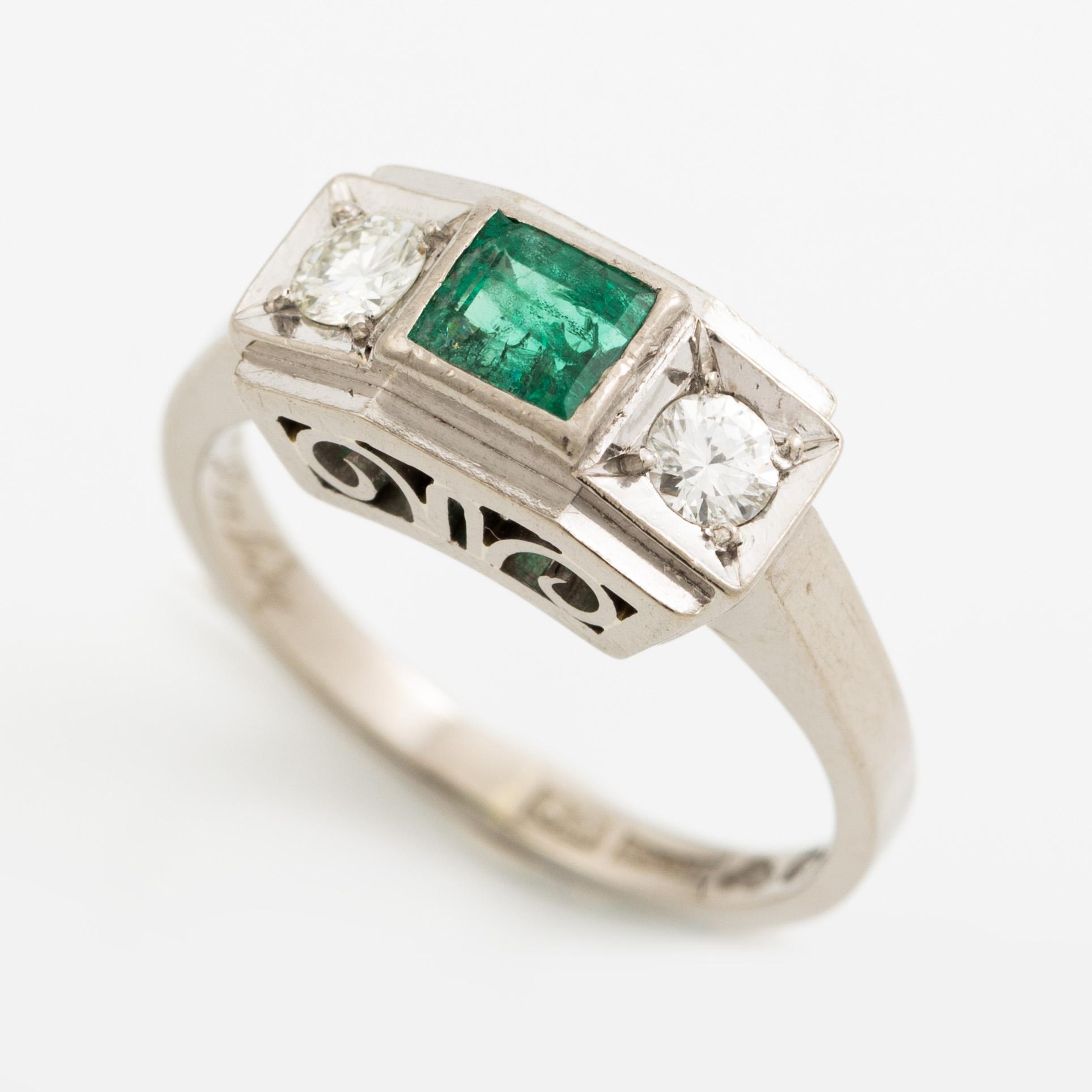 Ring, 18K vitguld med smaragd och två briljantslipade diamanter.