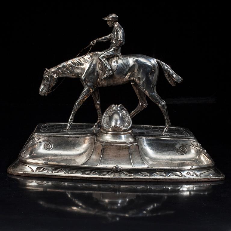 SKRIVSTÄLL med jockeyn Fred Archer till häst. Vitmetall. Sannolikt England, sent 1800-tal.