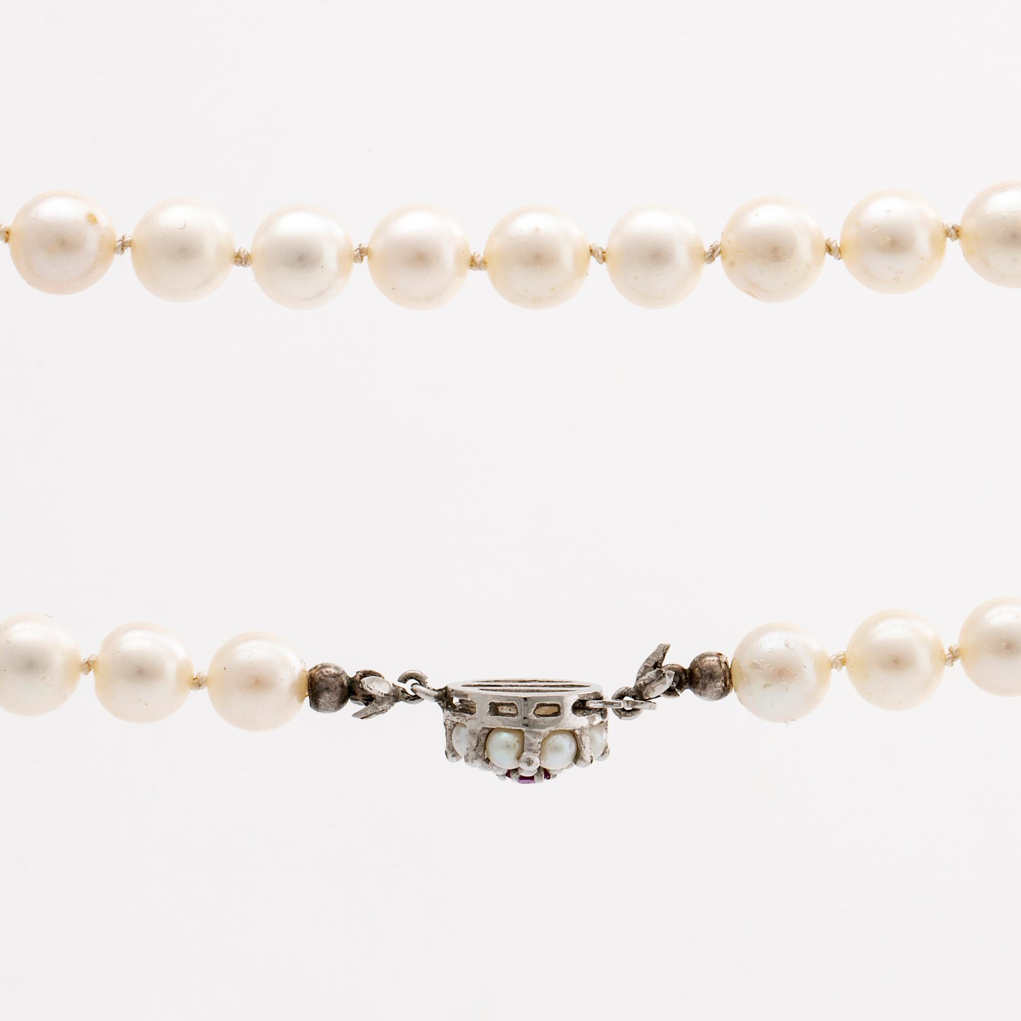 PEARL NECKLACE, cultured pearls approx 7 mm, clasp 18k whitegold cultured pearls and 1 ruby, approx length 93 cm.