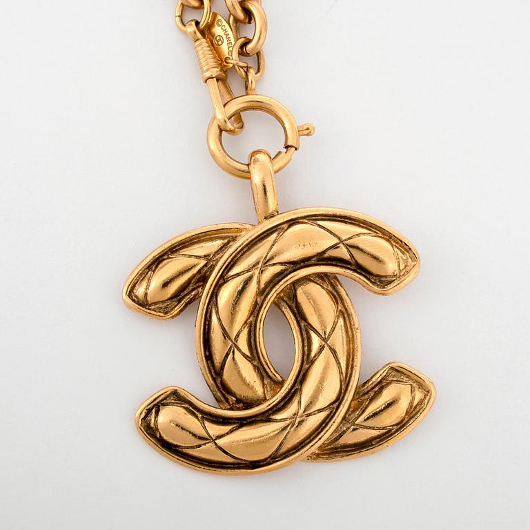 CHANEL a gold colored chain with pendant.