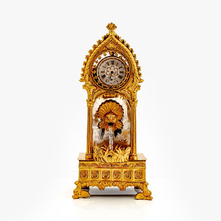 A mid 1800s gilded bronze pocket watch stand and pocket watch.