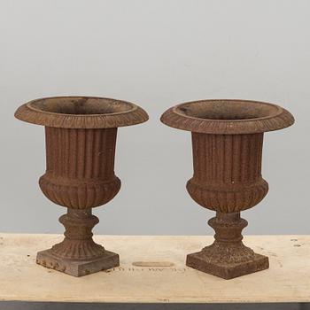 A PAIR OF IRON CAST GARDEN URNS.