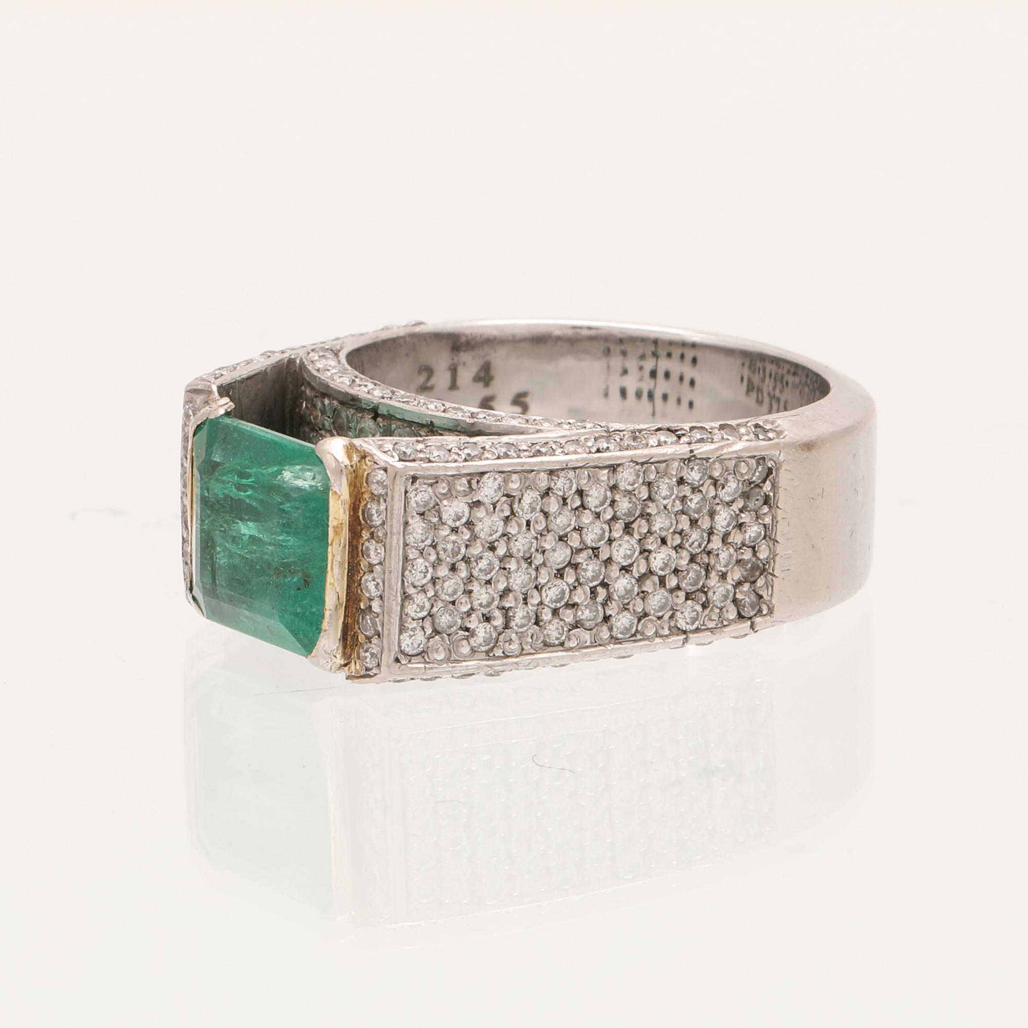 A 9K white gold ring with an emerald and brilliant cut diamonds.