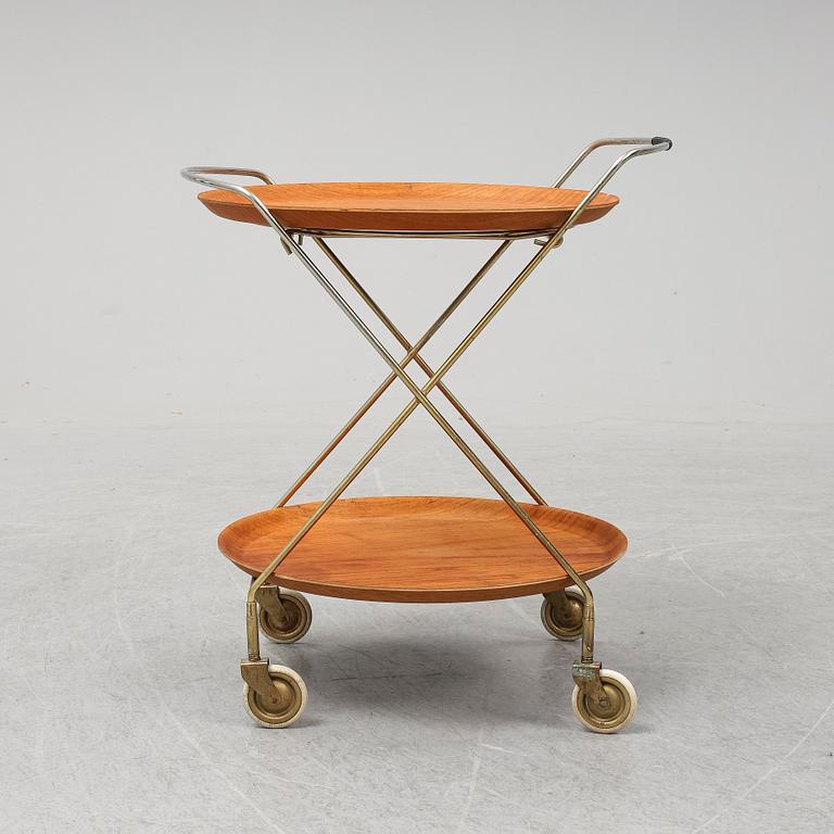 A drinks trolley from J-H Fabrikerna, Sävsjö, 1960-tal.Två lösa, runda brickor fanerade med teak. Märkta J-H Fabrikerna.