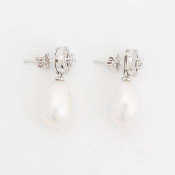 A pair of 18K white gold and cultured pearls earrings set with round brilliant-cut diamonds.