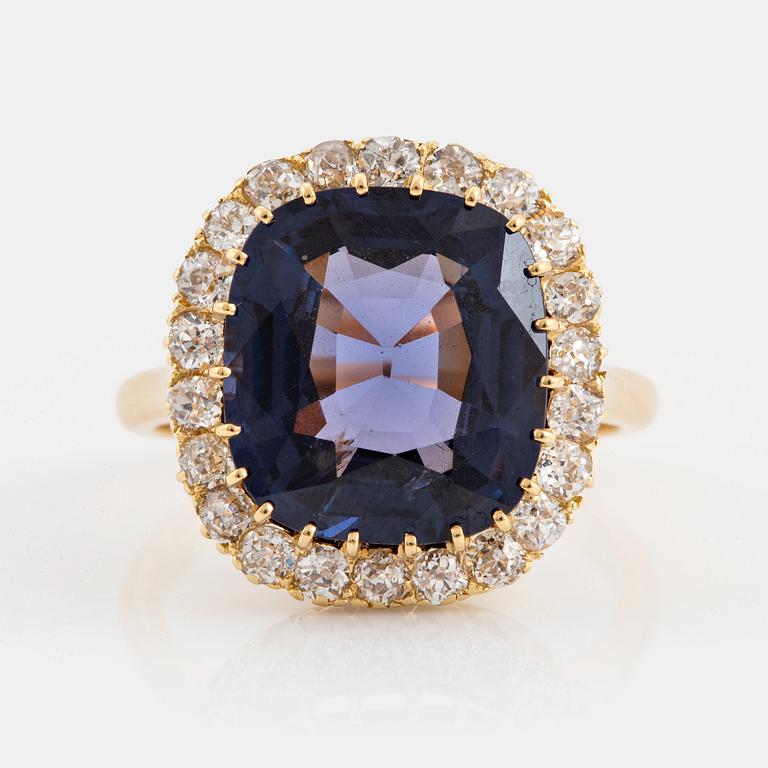 An 18K gold ring set with a cushion-cut purple spinel 6.15 cts according to information given.