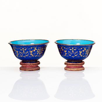A pair of gilt decorated blue ground painted enamel bowls, Qianlong four character seal mark and period (1736-95).