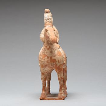 A painted pottery figure of an equestrian standard-bearer, Tang dynasty (618-907 AD.).