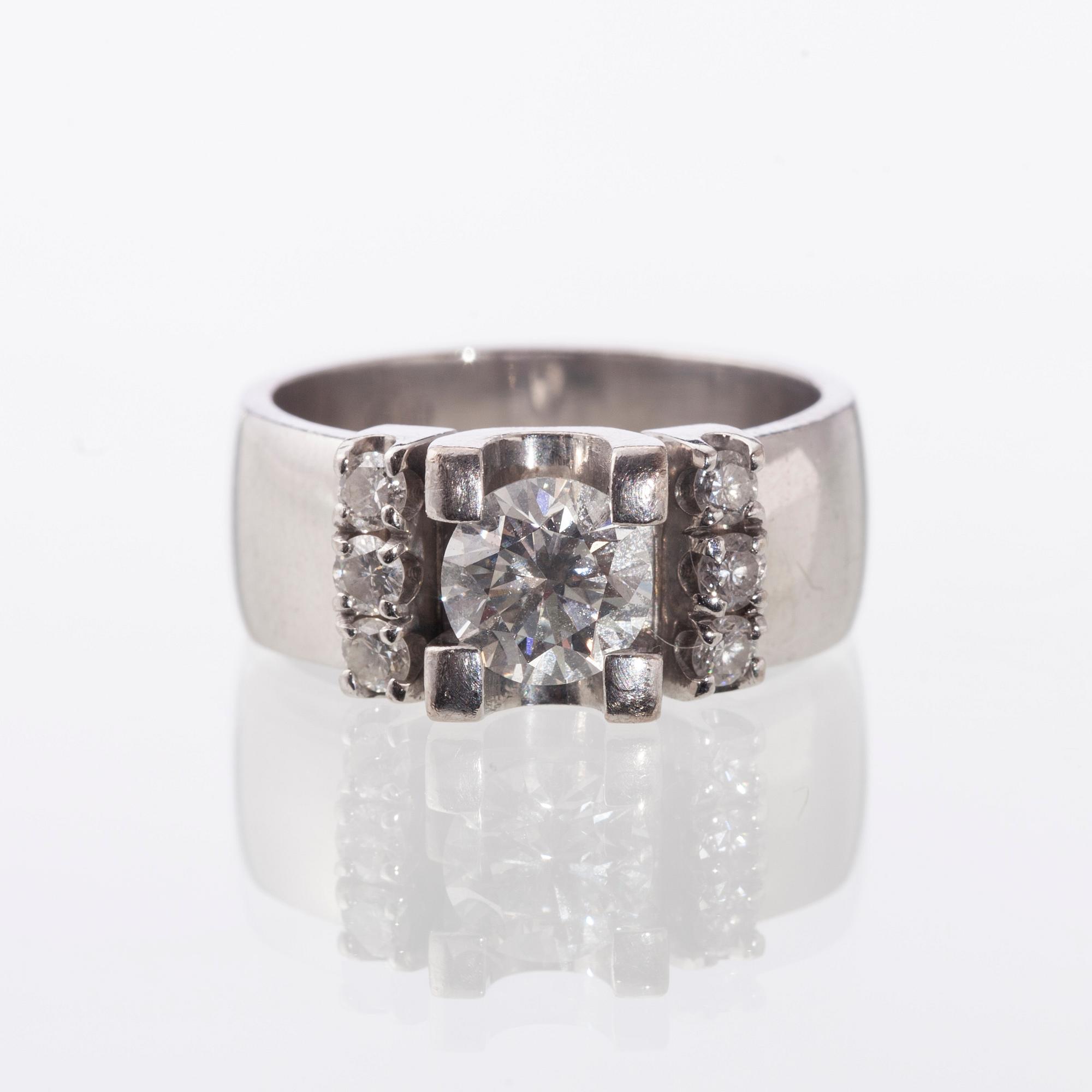 RING, 14K vitguld. Morris, briljantslipad diamant ca 1,00 ct, sidostenar tot. ca 0,30 ct. Vikt 10,8 g.