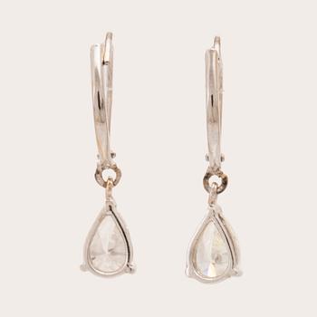 A pair of 18K white gold earrings set with pear cut diamonds.