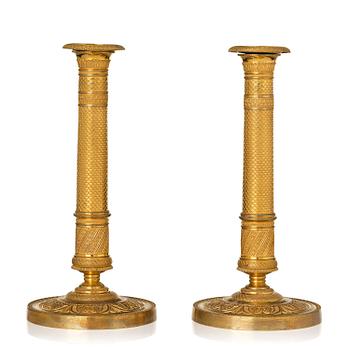 173. A pair of French Empire ormolu candlesticks, early 19th century.
